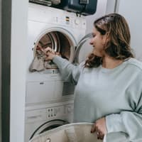 Stromfresser im Haushalt Frau räumt Waschmaschine ein